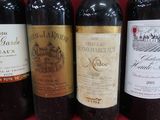 Plusieurs bouteilles de vin sont alignées sur une surface rouge