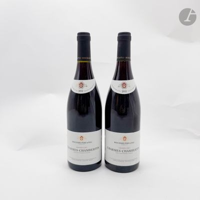 deux bouteilles de vin rouge posées l'une à côté de l'autre sur une surface blanche