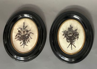 two framed pictures of flowers are on a wall in a black frame