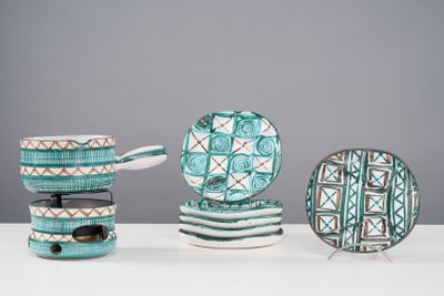 a white table topped with plates and bowls and spoons
