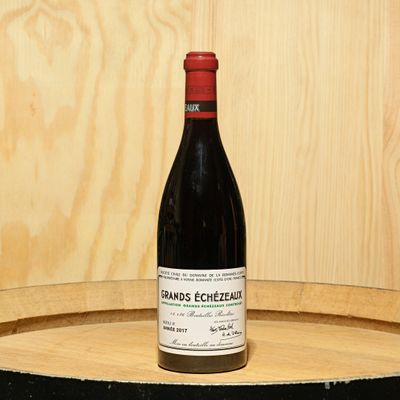 a bottle of wine sitting on top of a barrel
