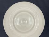 a white plate with a white rim sitting on a blue surface