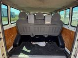 à l'arrière d'une camionnette dont la porte est ouverte, par une journée ensoleillée
