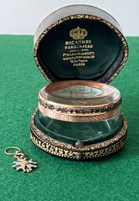 une petite boîte contenant une bague, posée sur une surface verte