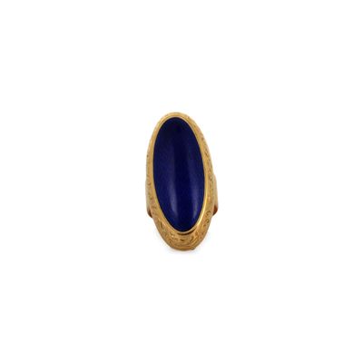 gros plan d'une bague en or avec une pierre bleue