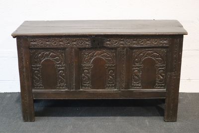 an old wooden chest sitting on top of a carpeted floor