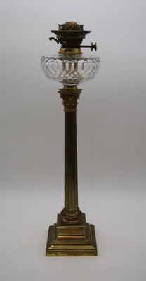 une lampe de table ancienne en laiton et cristal sur fond blanc