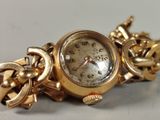 a gold watch with a chain around it on a table