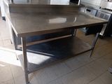 a large stainless steel table in the middle of a kitchen