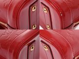 three red purses stacked on top of each other on a white surface