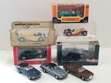 four different models of cars in boxes on a table