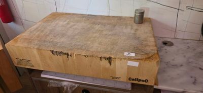 a wooden cutting board sitting on top of a kitchen counter