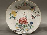 a plate with flowers and birds painted on it