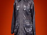 a black leather jacket on a mannequin stand against a red background