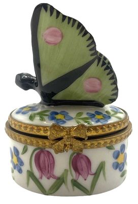 un papillon posé sur une boîte décorée de fleurs