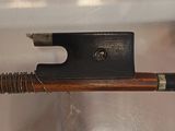 a close up of a violin bow with a wooden handle