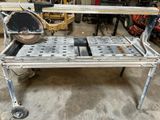 un établi métallique équipé d'une scie, dans un garage
