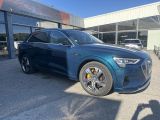 a blue audi suv parked in front of a building