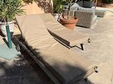 two chaise lounge chairs and an umbrella on the patio