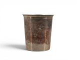 a metal cup that is sitting on a white surface