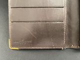 leather wallet with two credit cards in it sitting on a table