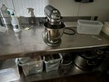 stainless steel counter top with a mixer and other kitchen items on it