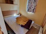 un lit dans une petite chambre avec une tête de lit en bois