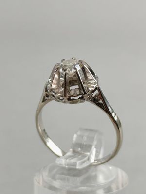 a close up of a diamond ring on a clear surface