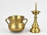 a pair of brass candlesticks and a vase