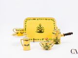 un service à thé jaune avec un plateau sur lequel sont posées des tasses