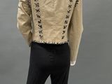 the back view of a mannequin wearing a beige jacket and black pants