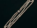 un collier de perles avec un fermoir en diamant sur fond noir