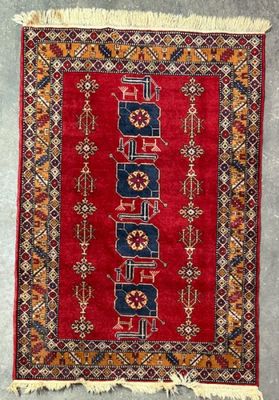 a close up of a red rug on a gray floor