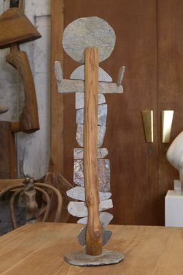 une table en bois sur laquelle se trouve une sculpture, dans une pièce