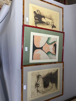a man standing in front of a wall with paintings on it