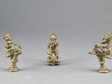 trois figurines en laiton représentant un homme et une femme jouant de la flûte