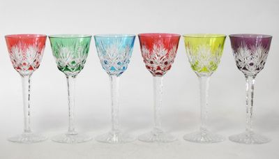 six different colored wine glasses are lined up in a row
