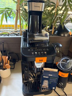 une cafetière noire posée sur un plan de travail près d'une fenêtre