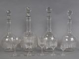 four clear glass wine glasses and a decanter on a table
