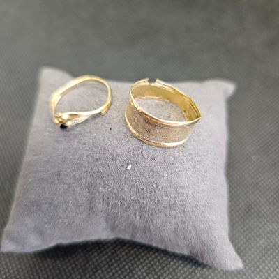deux bagues en or posées sur un coussin par terre