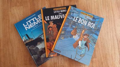 three books that are sitting on a wooden table