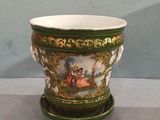 a green and white vase with a painting on it