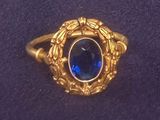 une image d'une bague en or avec une pierre bleue au centre