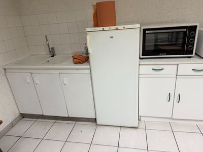 a small kitchen with a white refrigerator and white cabinets