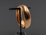 un gros plan d'une bague en or posée sur un socle noir