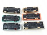 four different types of miniature trains on a white surface