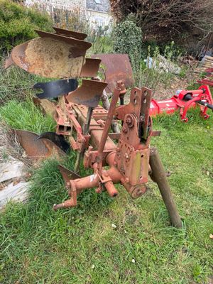 a tractor plow that is sitting in the grass