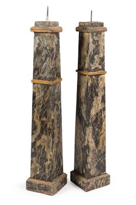 pair of marble pedestals with candles on top of them