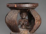 an old wooden table with a carved figure on top of it