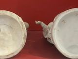 two white vases that are sitting on a table